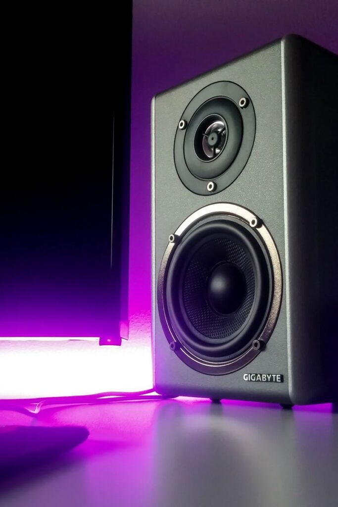 High-quality speaker setup with vibrant purple lighting in a modern studio setting.